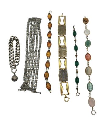 Plusieurs bracelets et colliers différents sont exposés sur un fond blanc.