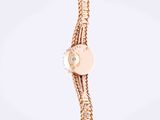 a close up of a gold watch with a chain around it