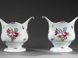 deux vases blancs ornés de motifs floraux, placés l'un à côté de l'autre