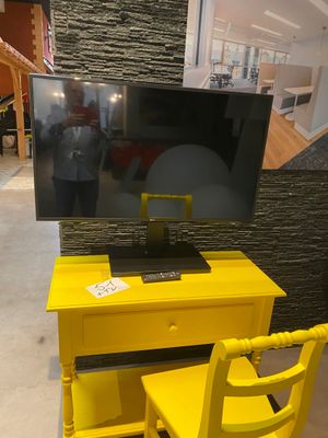 a yellow desk with a tv on it and a yellow chair