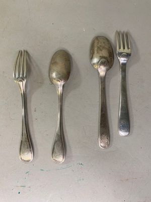 trois cuillères, une fourchette et un repose-cuillère posés sur une table