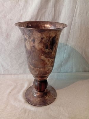 un vase en argent posé sur une table, sur fond blanc