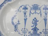 a blue and white plate with a picture of people on it