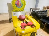 a yellow machine with a basketball ball on top of it
