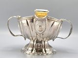 an antique silver teapot with a gold lid and handle