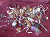 many different types of jewelry on a red cloth