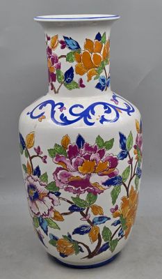 un vase blanc orné de fleurs colorées, posé sur une table