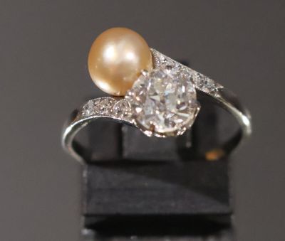 une bague de fiançailles ornée d'une perle et de diamants sur un fond noir