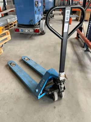 une photo d'un chariot élévateur dans un entrepôt, avec des palettes