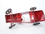 a red toy car that is sitting on a white surface