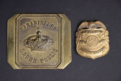 deux badges de police sur une surface noire avec un petit badge