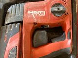 a red corded drill in a case with two other tools