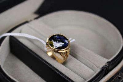une bague en or sertie d'une pierre bleue, dans un écrin