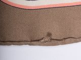 the back of a brown bag with a pink stripe on it