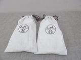 pair of white towels with black logos on them sitting on a bed