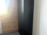 une photo d'une salle de bains avec des toilettes et un meuble noir