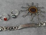 un bracelet en argent, une bague, un bracelet et d'autres bijoux posés sur une table