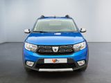 the front view of a blue dacia parked in a room