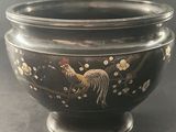 a black bowl with gold and white designs on it