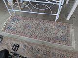 a white iron bed frame with a rug on it