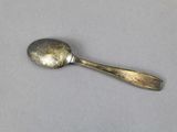 a silver spoon with a spoon handle on a table