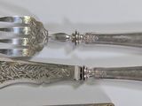 three forks and a knife on a white table