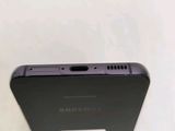 the back of a black samsung phone sitting on top of a white table