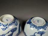 pair of blue and white vases with birds and clouds on them