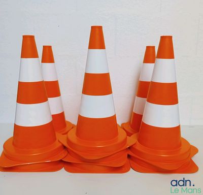 plusieurs cônes de signalisation orange et blancs posés sur une table blanche