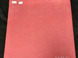 a red book sitting on top of a black cloth covered table