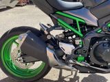 a green and black motorcycle parked in a parking lot