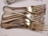 a lot of silverware on a table with a knife and fork