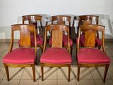 six wooden chairs with red upholstered seats in a room