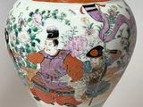 a vase with a painting on it sitting on a table