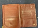 a brown leather wallet sitting on top of a blue carpet