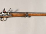 un vieux pistolet avec un canon en bois et une poignée en métal