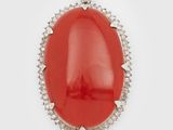 un pendentif ovale en corail et diamants sur fond blanc