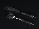 two forks and a knife on a black surface