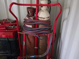 a red cart with a lot of gas bottles on top of it