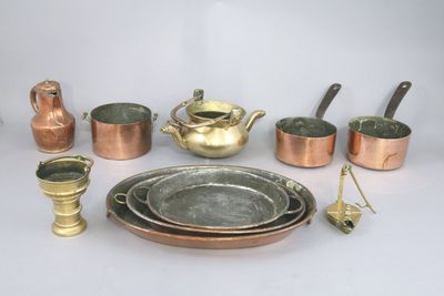 many different types of copper pots and pans on the table