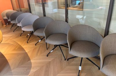 five chairs lined up in a row in front of a glass wall