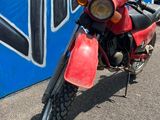 une moto rouge garée devant un mur bleu et blanc