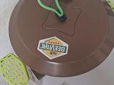 a brown plastic table with a green handle and a tennis racket on it
