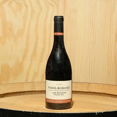 a bottle of wine sitting on top of a barrel