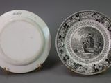 two plates with black and white designs on them sitting next to each other