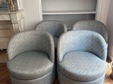 une paire de fauteuils pivotants bleus dans un salon, avec une bibliothèque en arrière-plan
