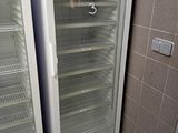 two empty refrigerators in the corner of a bathroom