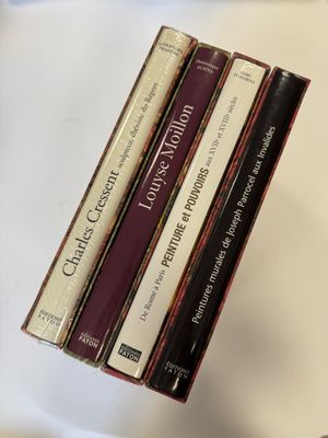 trois livres sont empilés sur une table