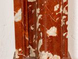 an image of a red and white marble clock sitting on a wooden table