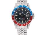 a close up of a wrist watch with a red and blue bezel
